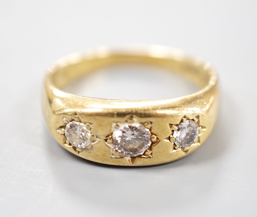 An 18ct gold and three stone gypsy set diamond ring, size S, gross weight 7.1 grams.